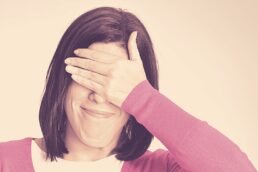 Frau hält sich die Augen zu mit ihrer Hand